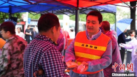 郴州北湖区志愿者为滞留旅客送来免费的面包和水。　　周峰 摄