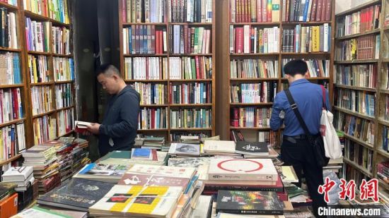 4月19日，湖南长沙，游人在二手书店内挑选所需书籍。　张雪盈 摄